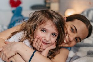 Photo of charming adorable little girl and her older sister teenager hugging each other